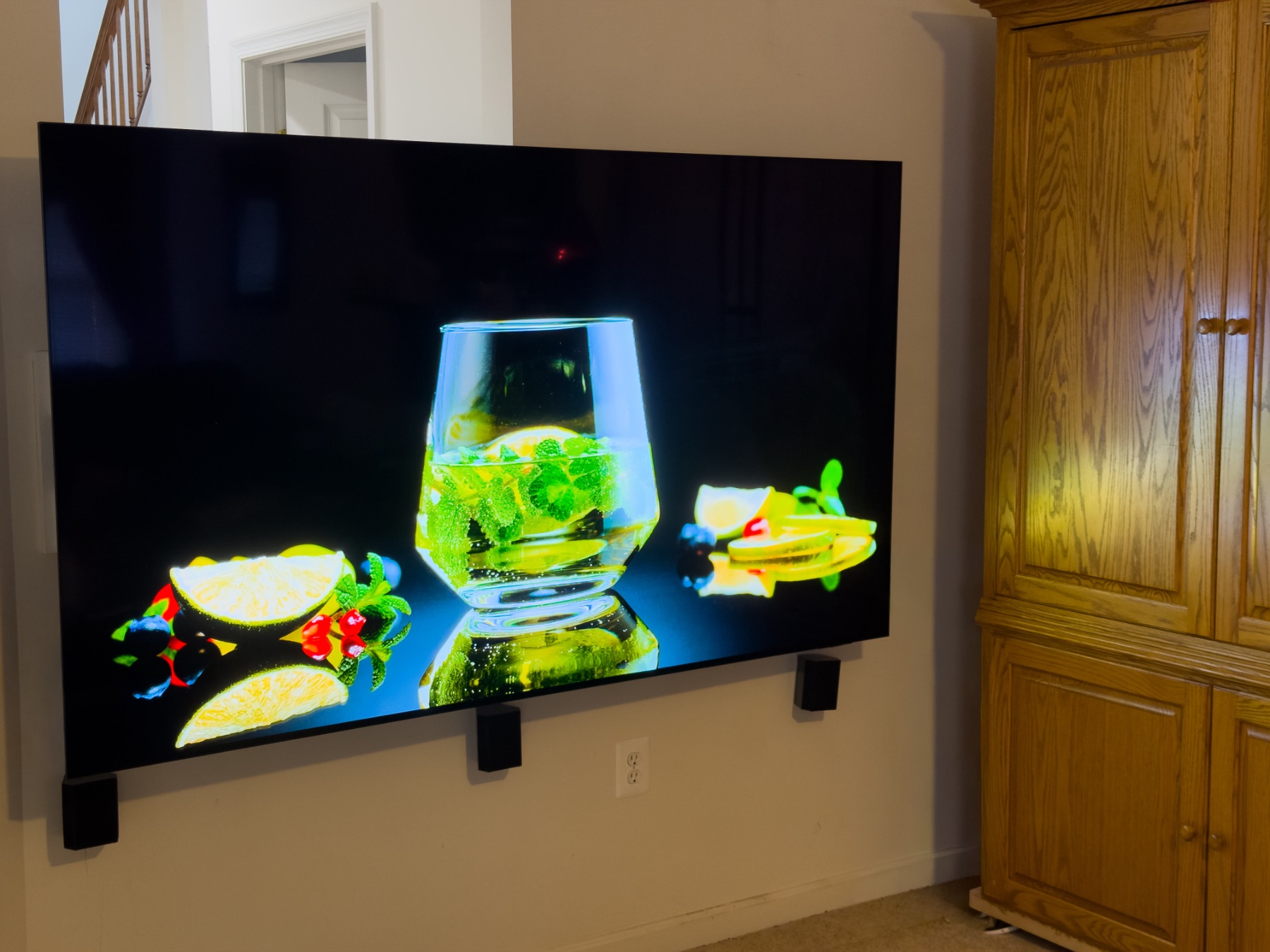 Wall-mounted TV with surround speakers, wires fully hidden, in a Severna Park living room